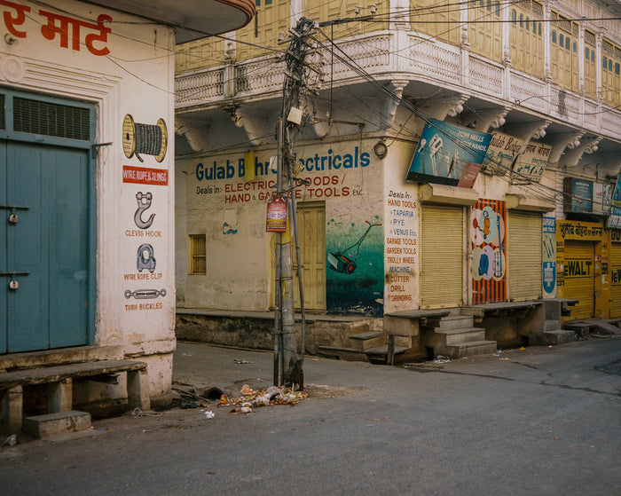 "Gulab Bohra Electricals" by Saleem Ahmed. An Inkjet Print depicting a series of closed shops. Photography, Color, Cityscapes, Urban Landscapes. The Print Center